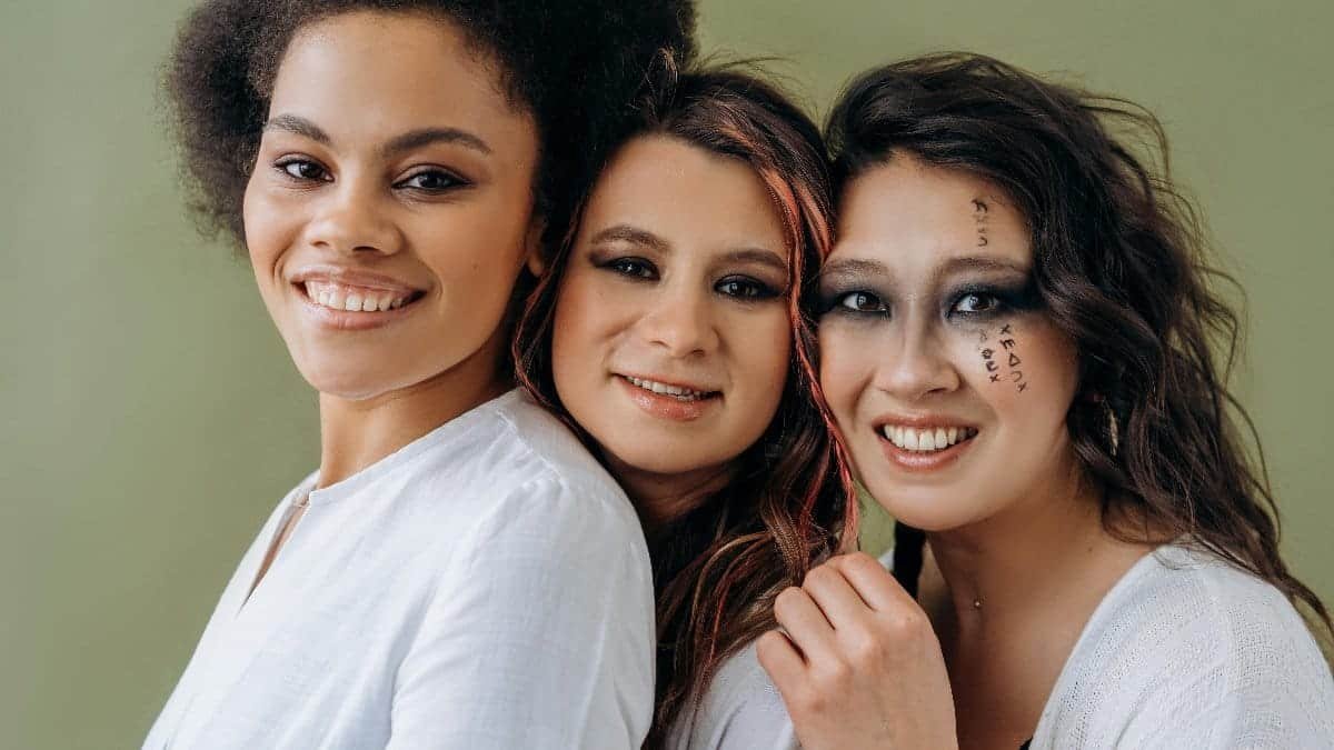 Three women sharing a joyful moment, showcasing diversity and friendship.