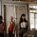 Three teens stand in a shabby, abandoned building for an adventure.
