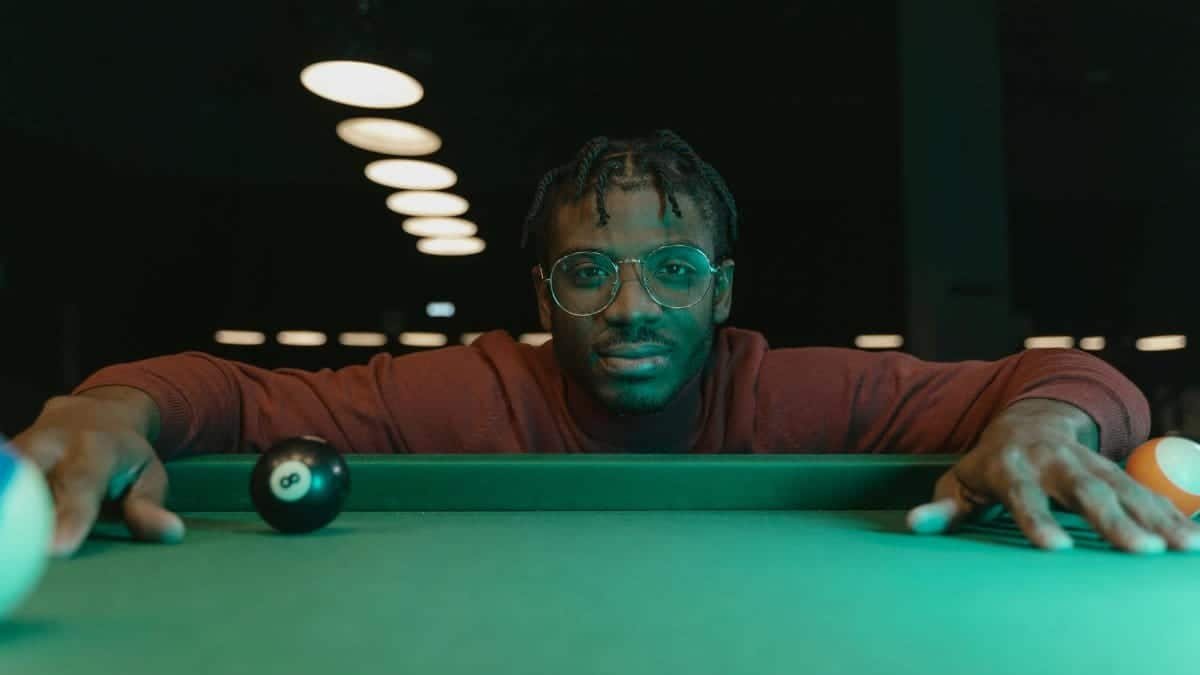 Man focusing intently on a billiard shot, showcasing precision and skill.