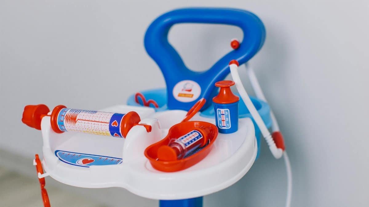 Bright toy medical set with syringes and bottles on white tray for kids' role play.