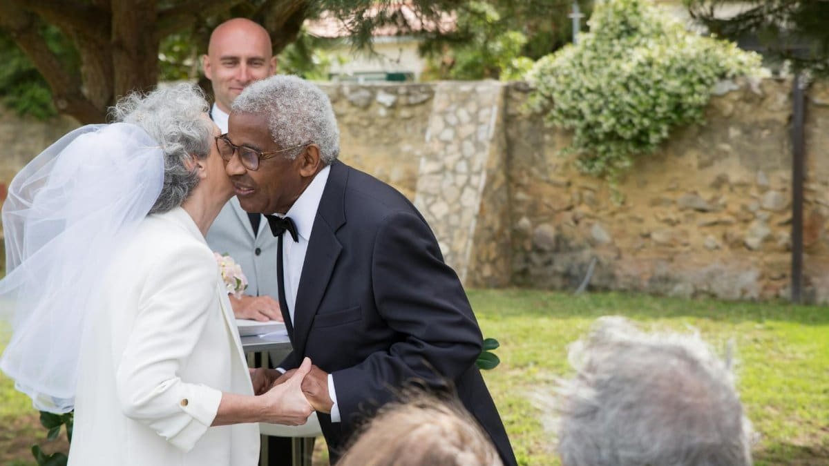 Senior couple renewing vows outdoors in Portugal, embracing love in a beautiful setting.