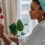 Woman creating a vision board with images in a stylish home setting, showcasing creativity and focus.
