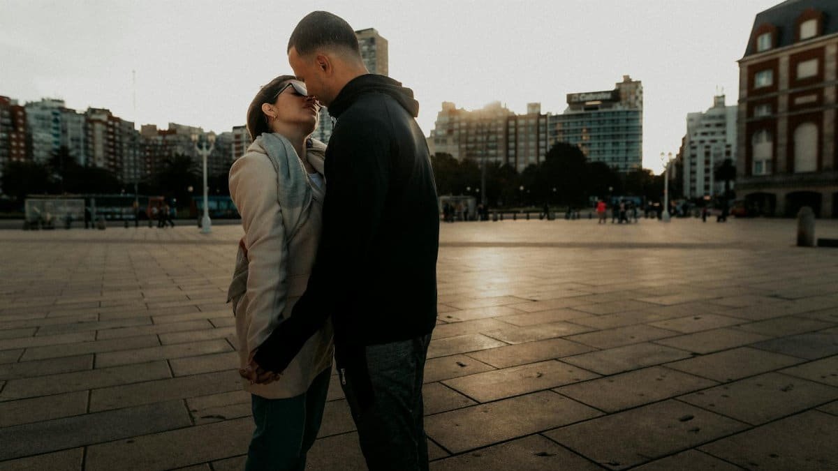 A couple embraces at sunset in Mar del Plata, showcasing love and connection.