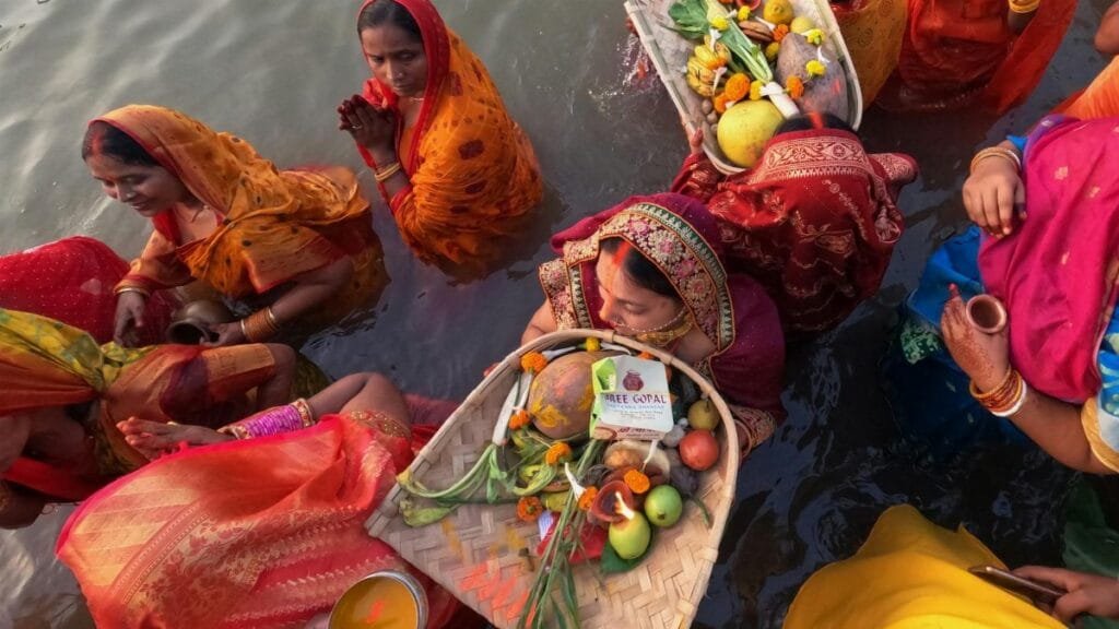 Women celebrate Chhath Puja in Kolkata, offering prayers and rituals by the river.