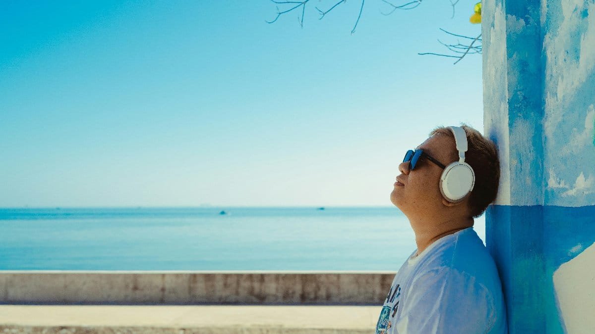 A person enjoys music by the seaside in Bình Thuận, Vietnam under the summer sun.