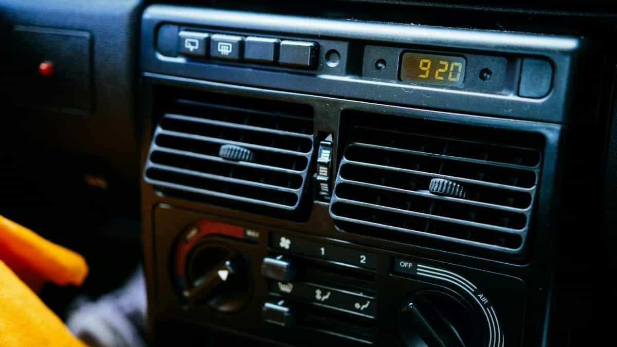 Detailed view of a car's dashboard featuring control knobs and a digital clock display.