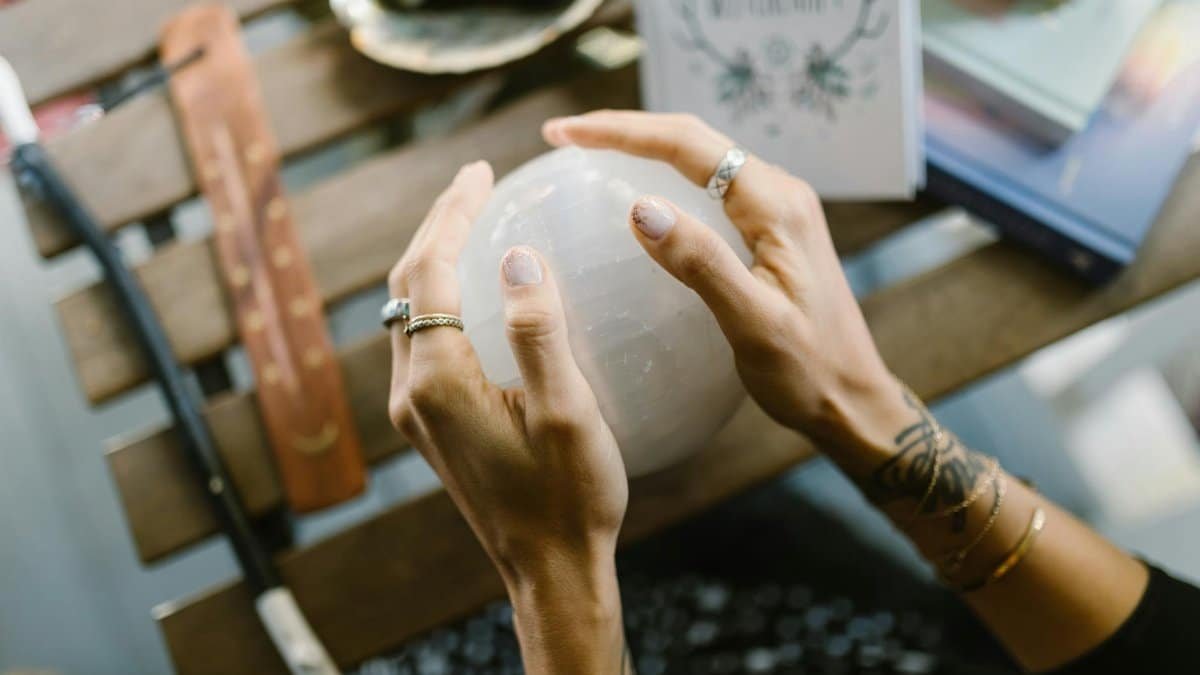 Mysterious image of hands holding a glowing crystal ball, hinting at magic and divination.