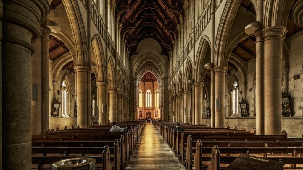 A beautifully detailed interior of a gothic-style historic cathedral with arches and pews.
