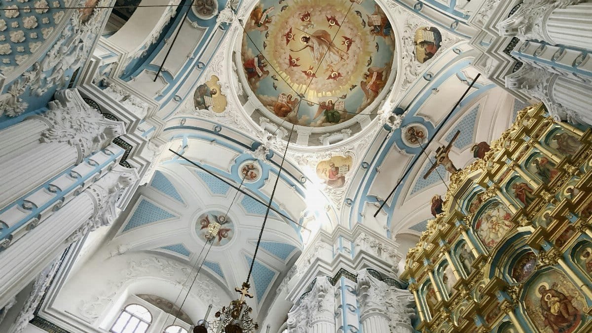Interior shot of a Russian Orthodox church with ornate ceilings and religious icons, showcasing detailed architecture and artwork.
