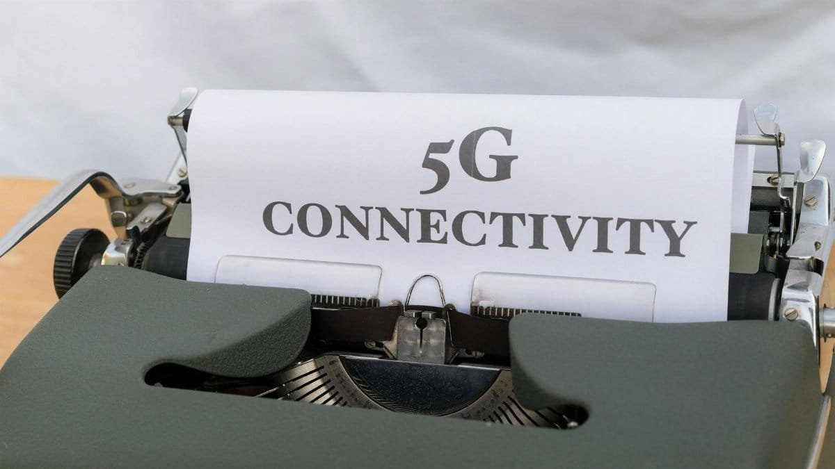 Close-up of a typewriter with a sheet of paper displaying '5G Connectivity', juxtaposing old and new technology.