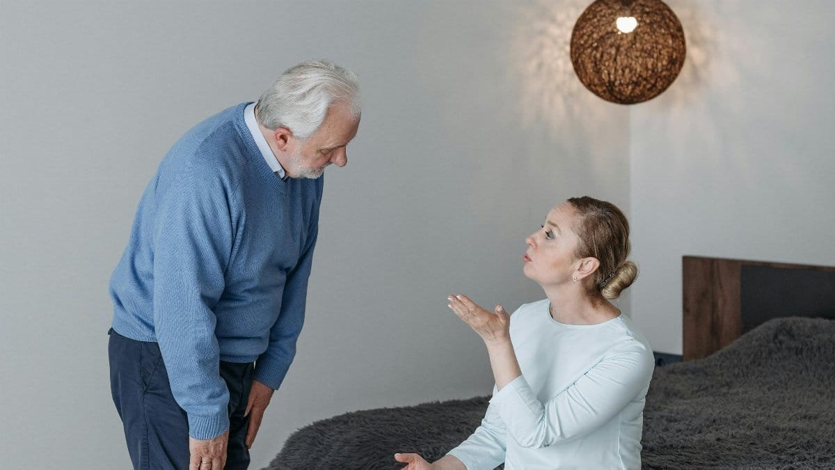 Elderly couple in a heartfelt conversation indoors, expressing emotions and connection. via Pexels