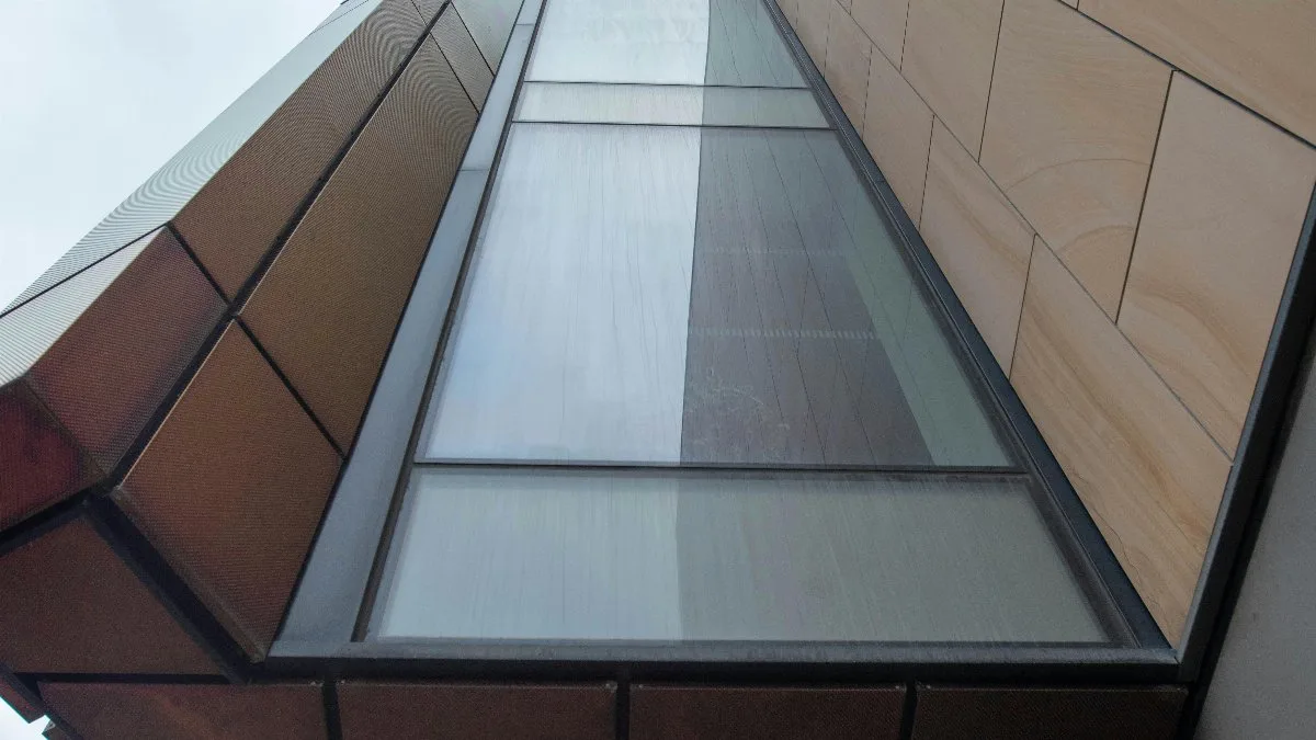 A striking view of contemporary architecture capturing geometric shapes and glass facade from below.
