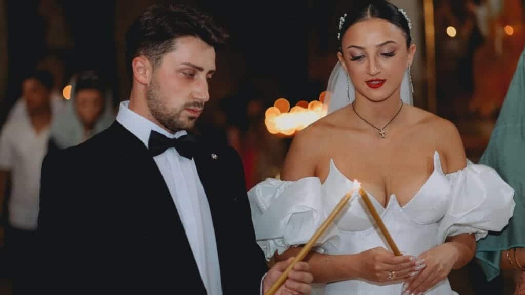 Bride and groom participate in a traditional candle lighting ceremony during their wedding.