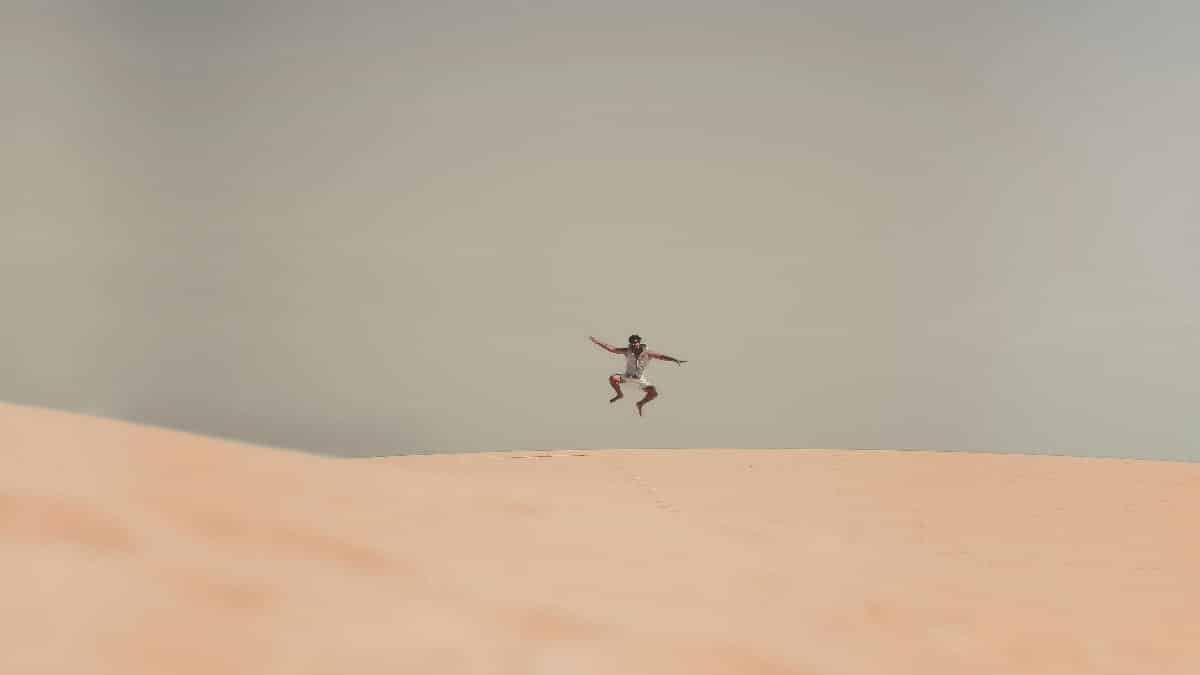 A lone person captured mid-air in a desert landscape, showcasing adventure and freedom in Egypt.