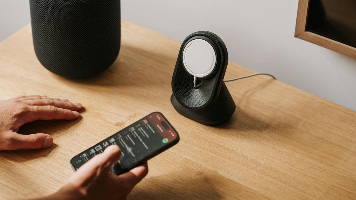A modern desk setup featuring tech gadgets with a smartphone and smart speaker.