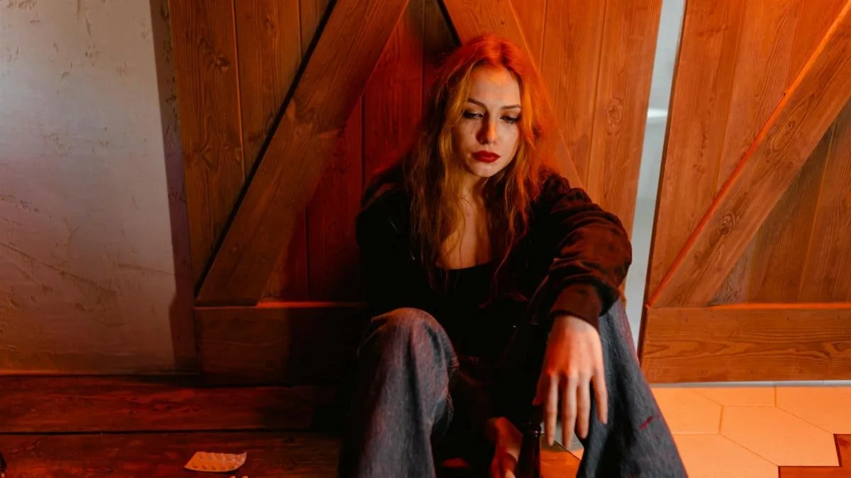 Emotional woman sitting indoors depicts solitude and contemplation.