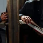 A priest listening to a man's confession inside a church, symbolizing faith and spirituality.
