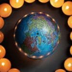 A globe encircled by lit candles symbolizes global unity and peace. via Pexels