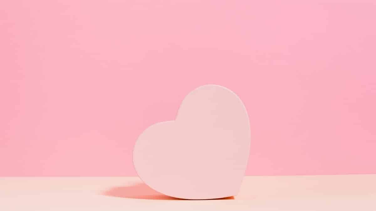 Simple and elegant pink heart shape on a pastel pink background, perfect for Valentine's Day themes.