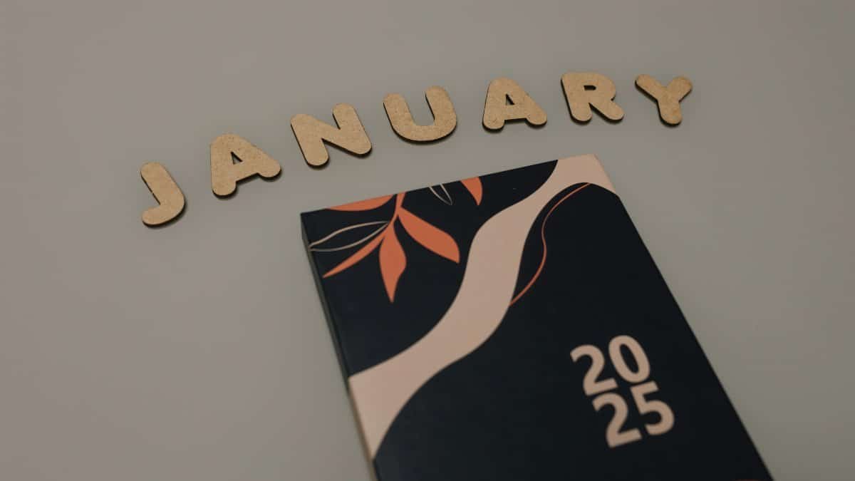 Flat lay of a 2025 planner with 'January' spelled in wooden letters. Perfect for organization lovers.