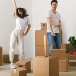 Young couple joyfully unpacking boxes in their new home.