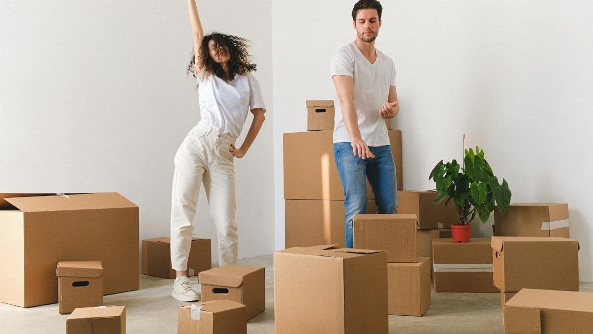 Young couple joyfully unpacking boxes in their new home.