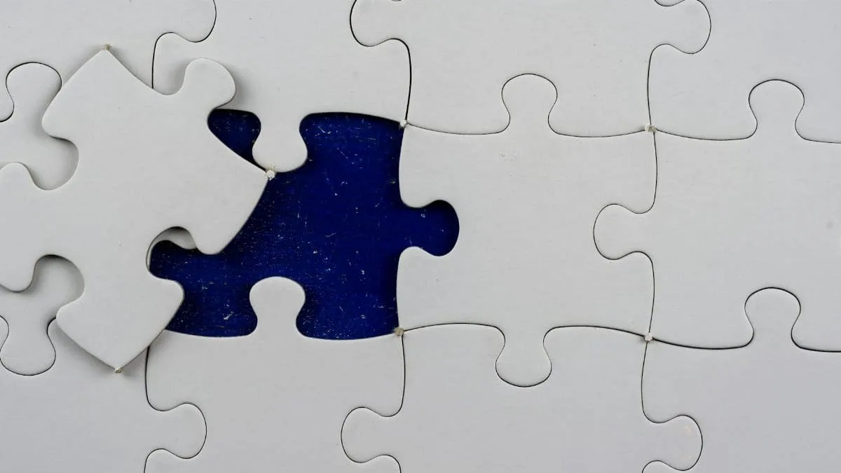 An artistic close-up of a puzzle with one missing piece revealing a contrasting background.