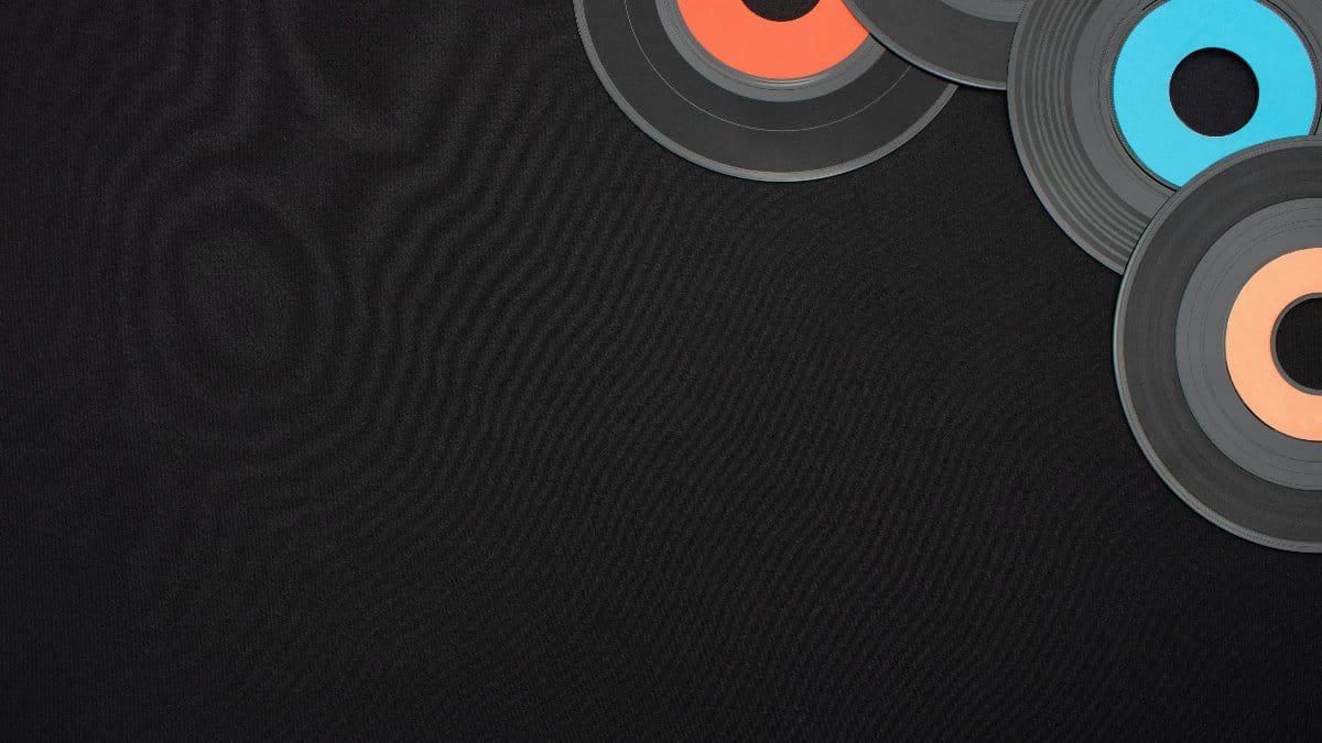Top view of colorful vinyl records on a black background, perfect for nostalgic musical themes. via Pexels