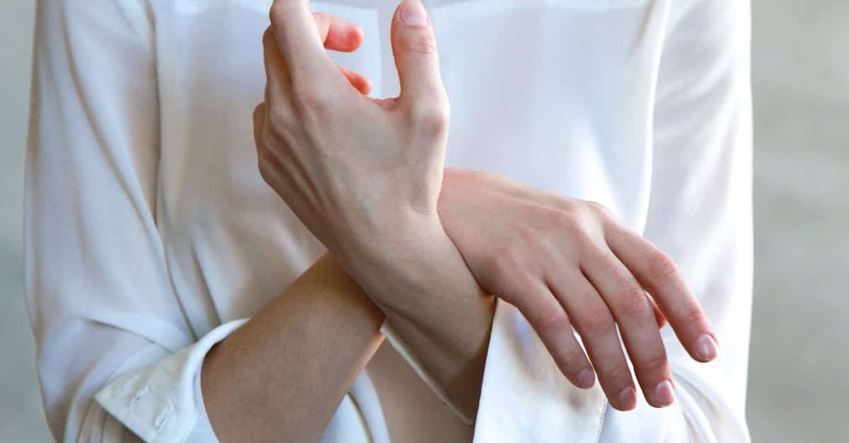 Elegant hands in a white shirt gently touching each other, symbolizing calm and tenderness via Pexels.