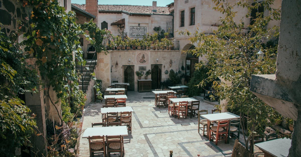 Rustic courtyard with vintage architecture and outdoor seating, perfect for dining via Pexels.