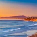 Golden sunset over a serene California coastline, with rolling waves meeting the sandy shore via Pexels.