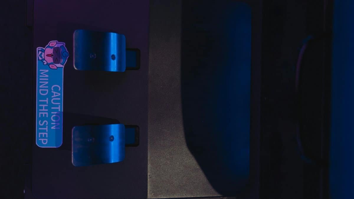Close-up photo of pedals with a caution sign under blue lighting, highlighting safety.