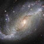 Capture of the NGC 1672 spiral galaxy showcasing its majestic spiral arms and bright core. via Pexels