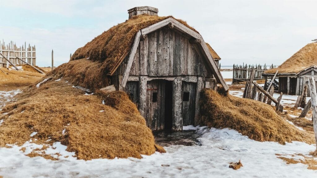 Shabby wooden house with grass covered roof in snowy terrain with forgotten village via Pexels