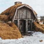 Shabby wooden house with grass covered roof in snowy terrain with forgotten village via Pexels