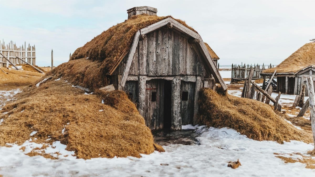Shabby wooden house with grass covered roof in snowy terrain with forgotten village via Pexels