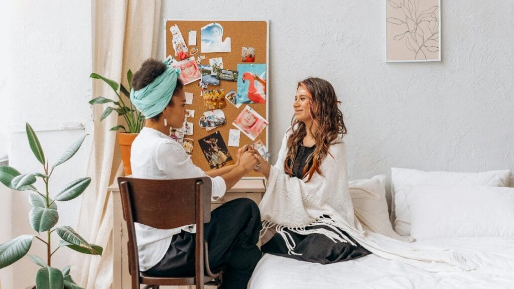 Two women sharing a mindful and spiritual moment in a cozy, indoor setting, promoting wellness and connection. via Pexels