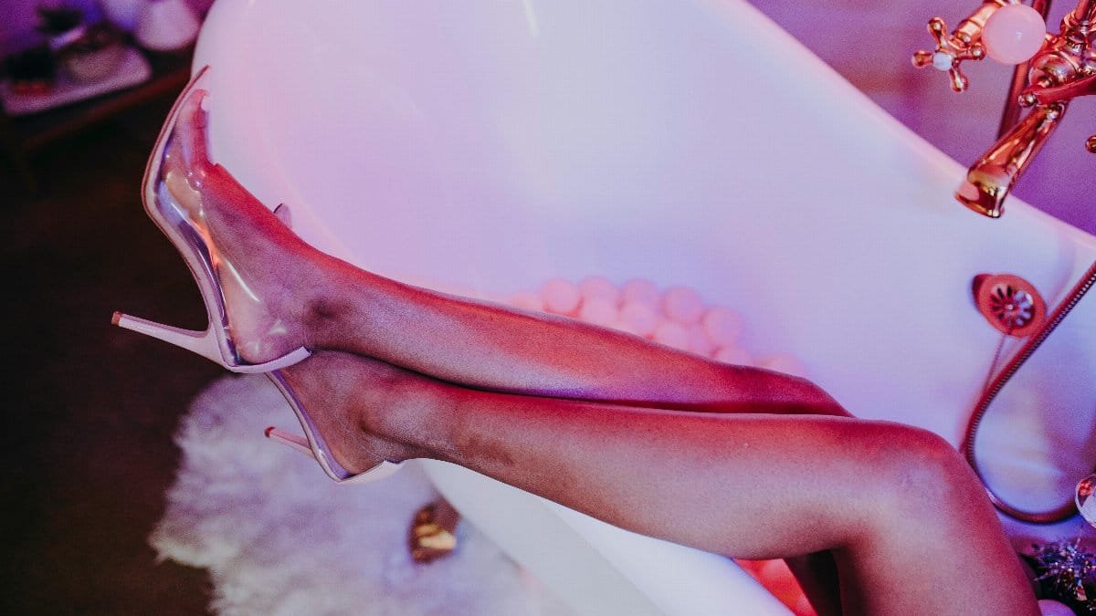 Trendy high heels and relaxed legs in a stylish bathtub setting. Modern luxury vibe.