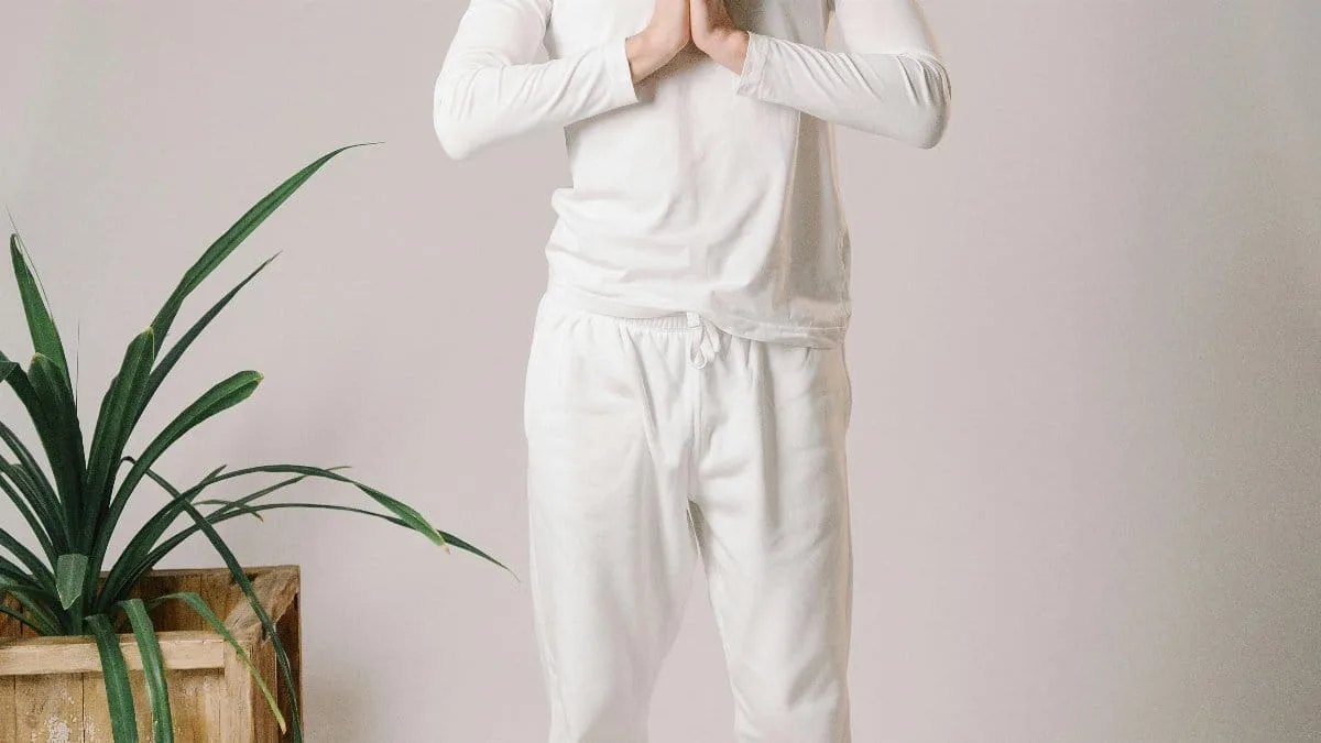 Man practicing mindful meditation indoors, focusing on balance and wellness.