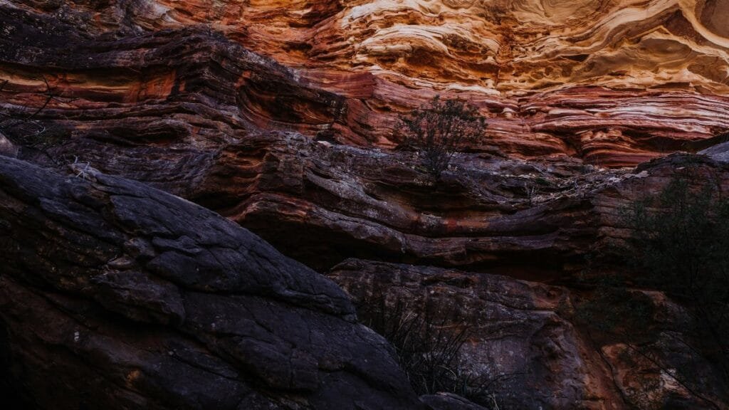 Detailed view of colorful sedimentary rock layers in a canyon wall. via Pexels