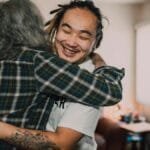 A joyful hug between friends in a cozy room, capturing warmth and friendship. via Pexels
