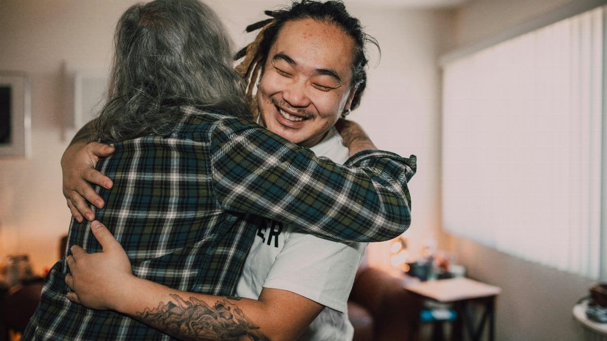A joyful hug between friends in a cozy room, capturing warmth and friendship. via Pexels