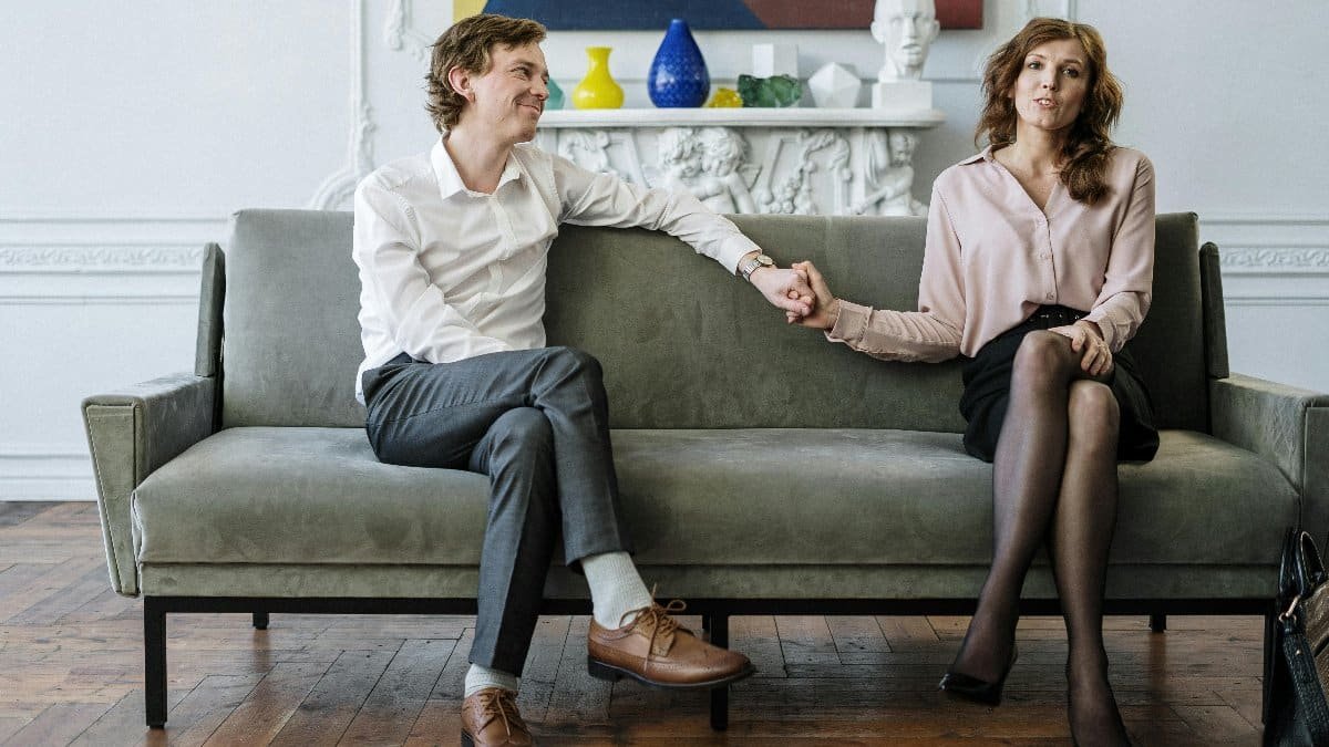A couple in a therapy session holding hands, conveying support and connection.