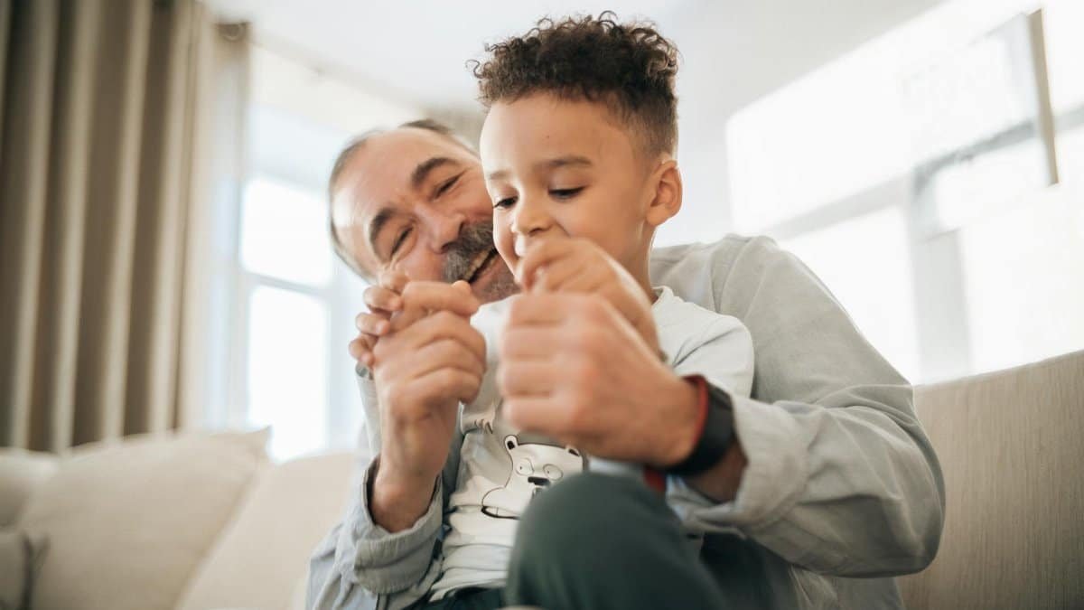 A grandfather and grandson enjoying playful quality time at home, showcasing family bonding.