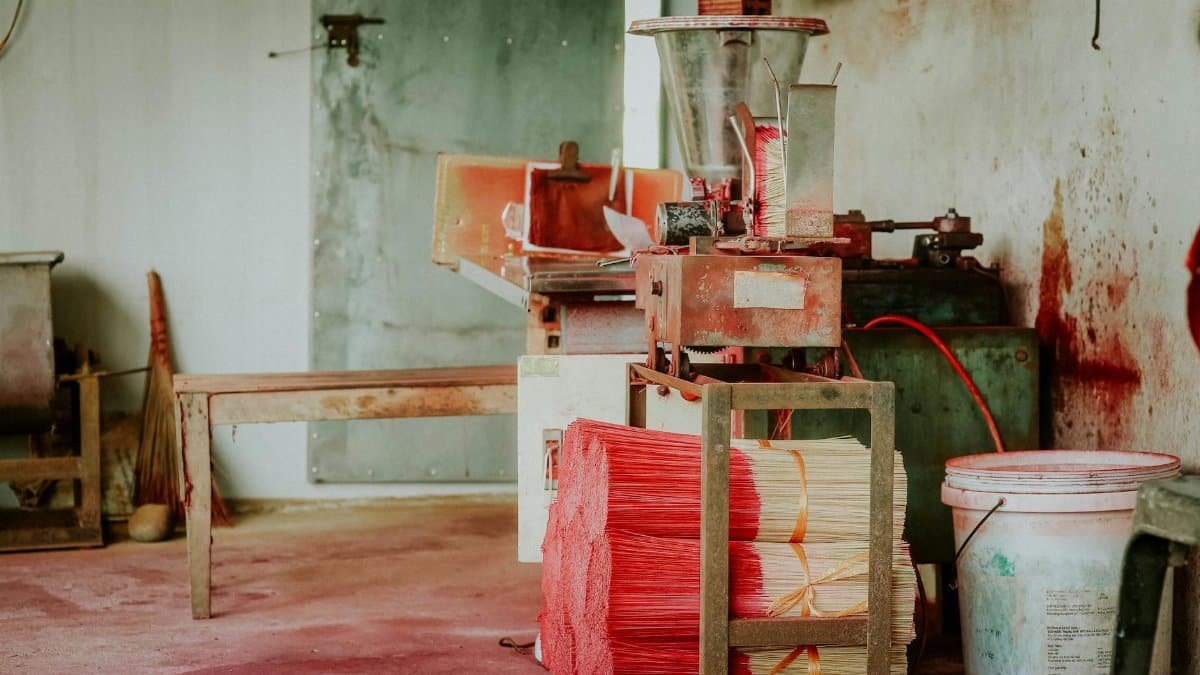 A rustic and abandoned industrial workshop featuring vintage machinery and tools.