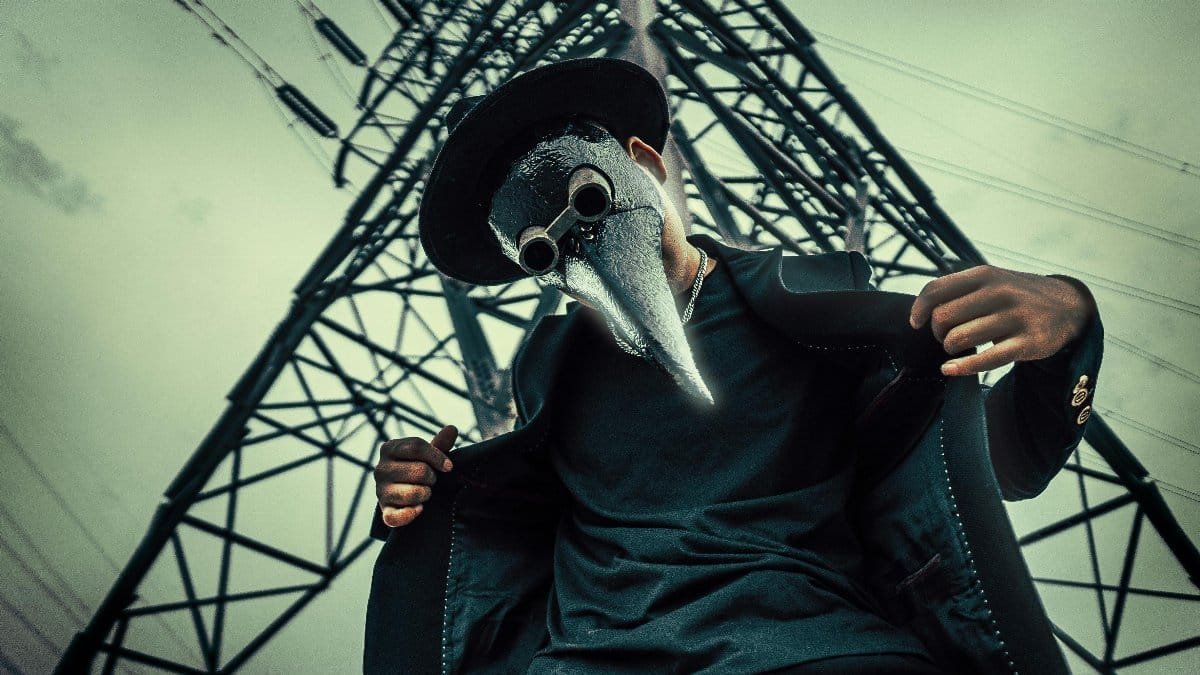A person wearing a plague doctor mask under a power line tower in Mashhad, Iran.