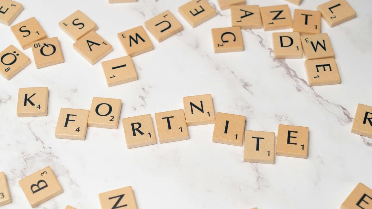 Scrabble tiles spelling Fortnite on a marble surface, ideal for gaming concept art.