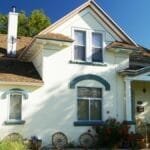 A picturesque suburban American house with a front yard and patriotic decorations.