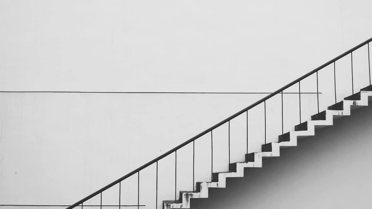 Minimalistic black and white staircase with sharp angles and clean lines, showcasing modern architecture.