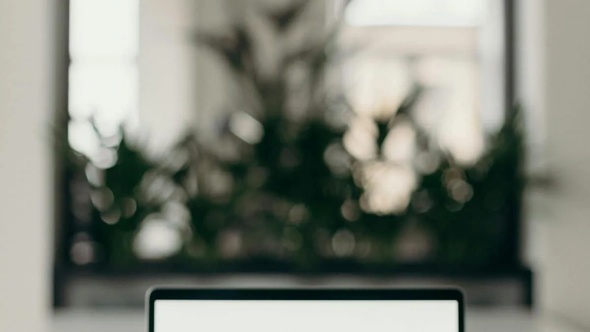 A minimalist workspace featuring an open laptop in a bright, serene indoor setting.
